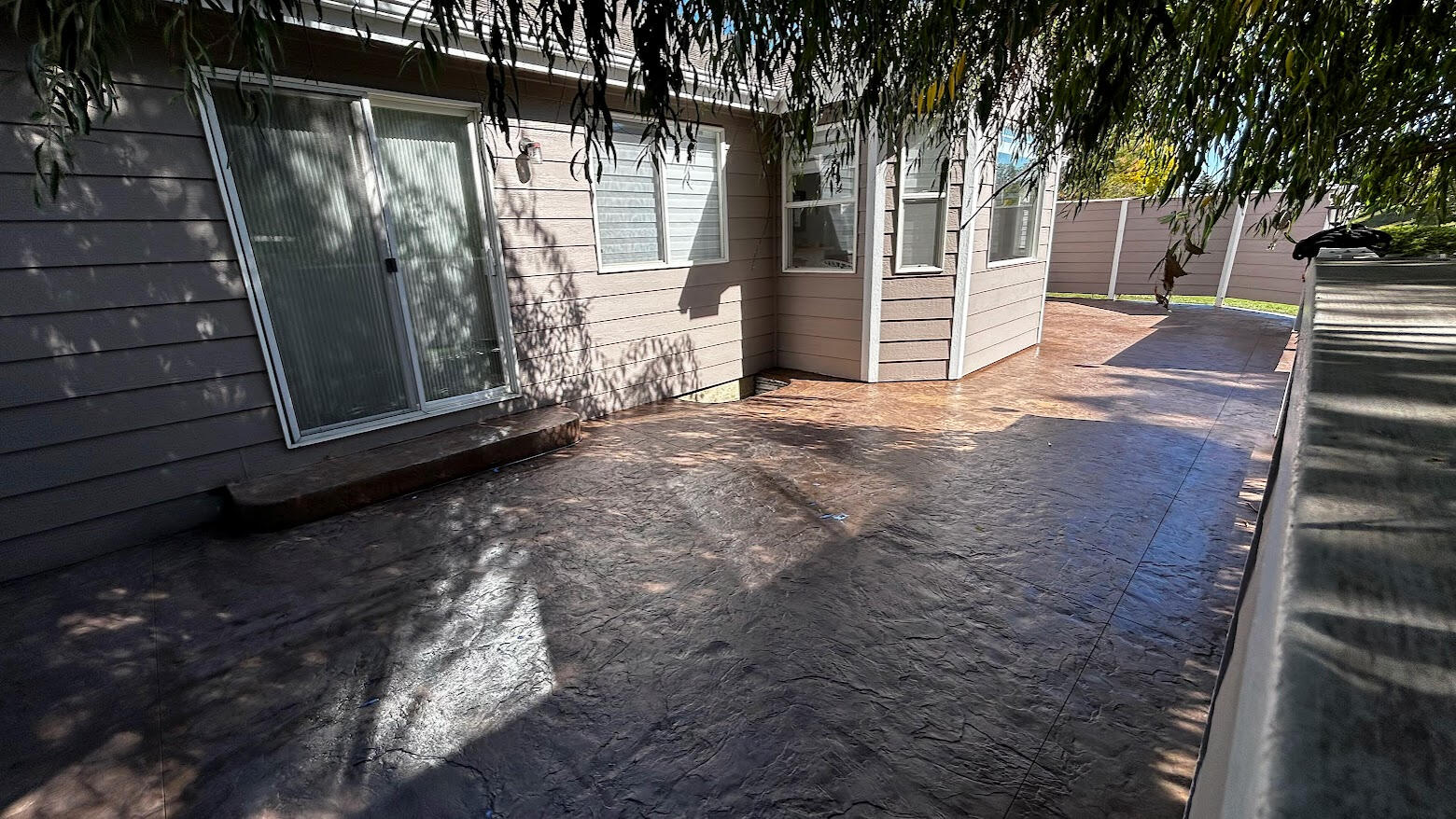 Stamped concrete patio in Fort Collins, Colorado along a home exterior with textured finish for durable outdoor living space.