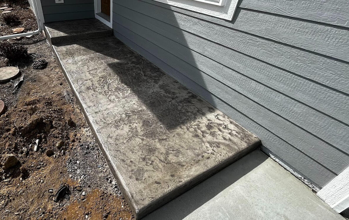 Stamped concrete porch in Loveland, CO with a gray textured finish, designed for durability and a natural stone appearance
