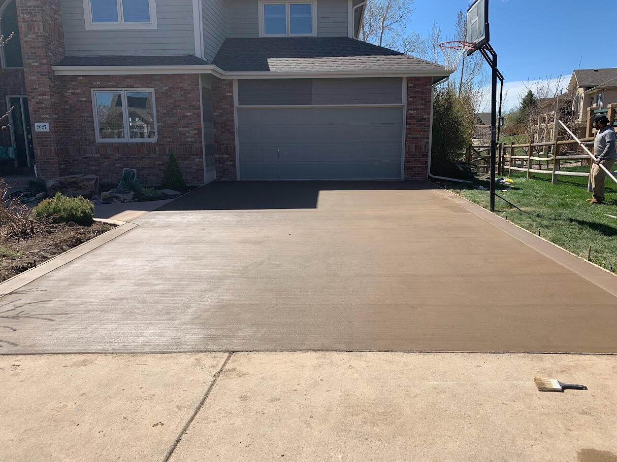 Colored concrete driveway in Fort Collins, CO with a broomed finish, installed for durability and enhanced curb appeal