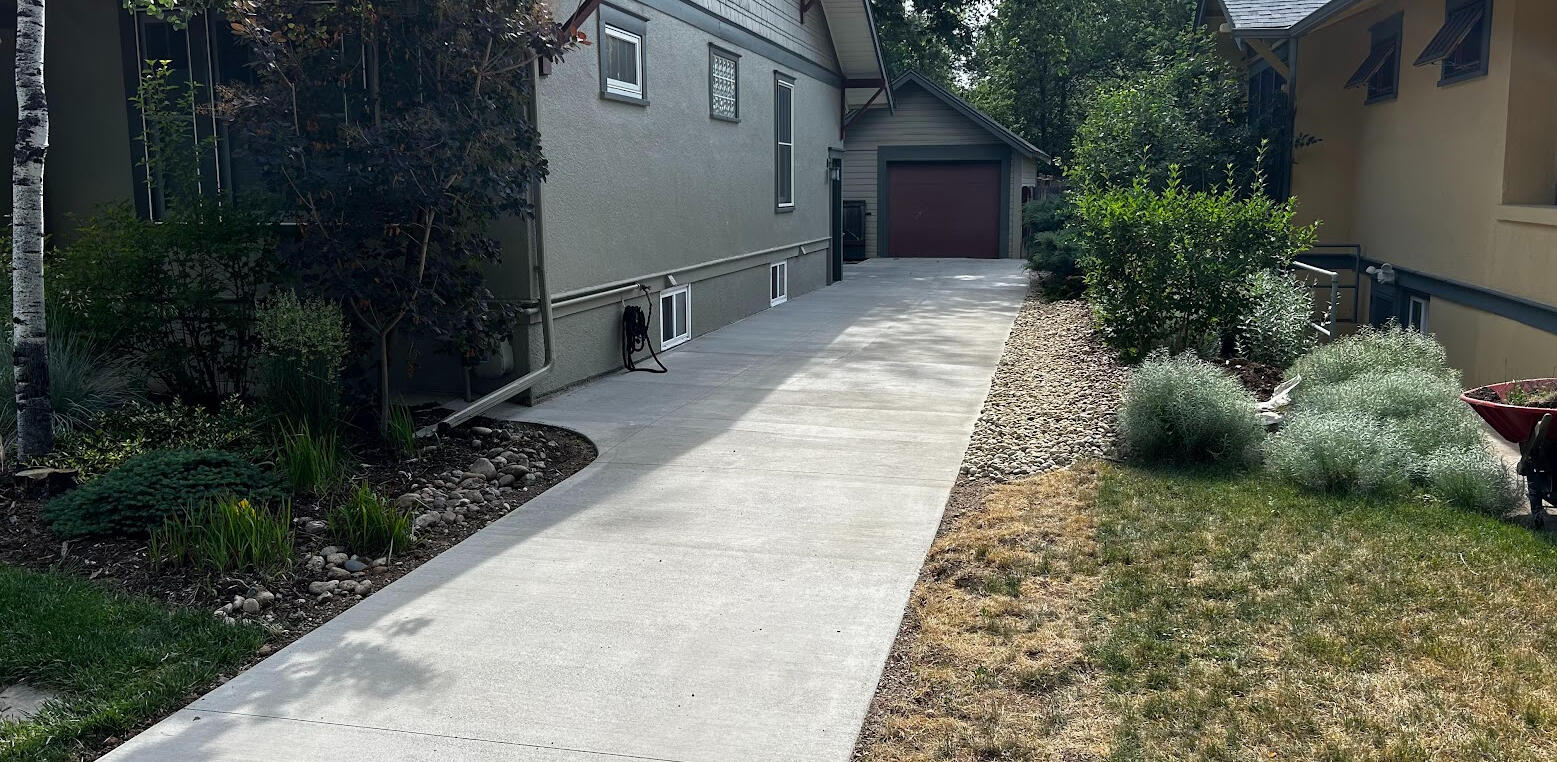 Long concrete driveway in Fort Collins, CO with a clean broom finish, offering durable access to a detached garage