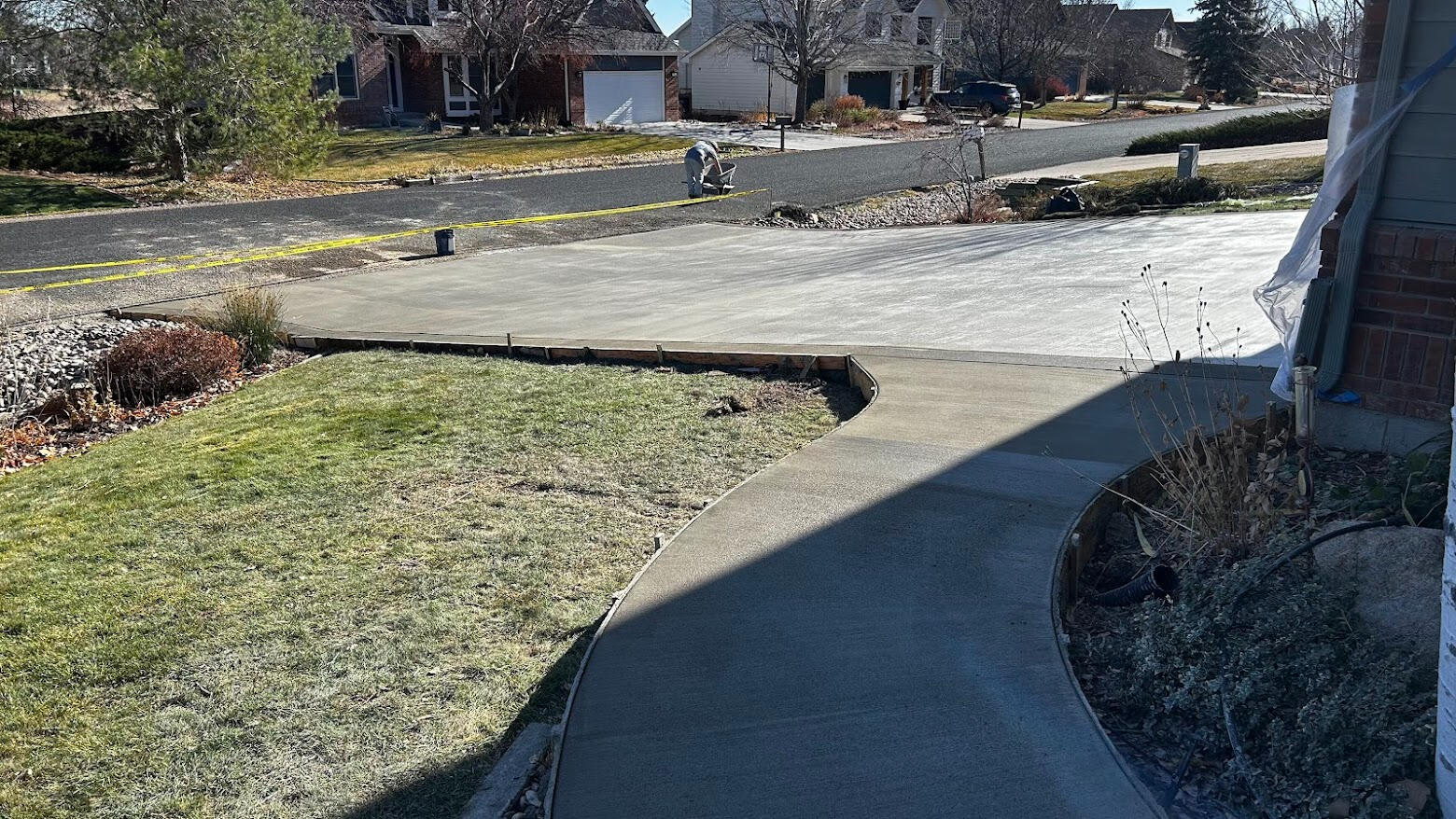 Concrete driveway and curved walkway in Fort Collins, CO with a clean broom finish, providing safe and durable access