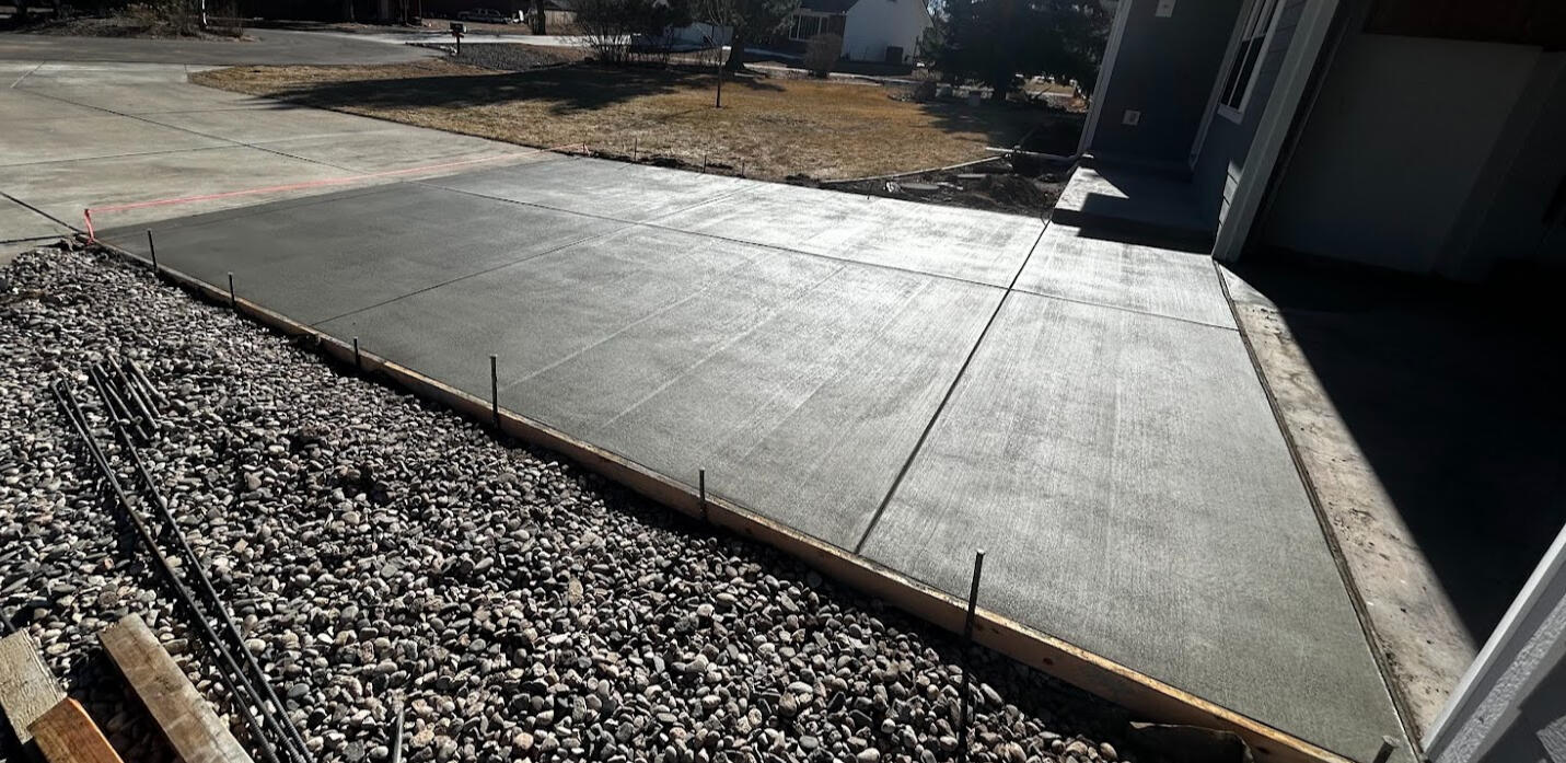 Freshly poured concrete driveway in Loveland, Colorado with a clean broom finish and precise edging.