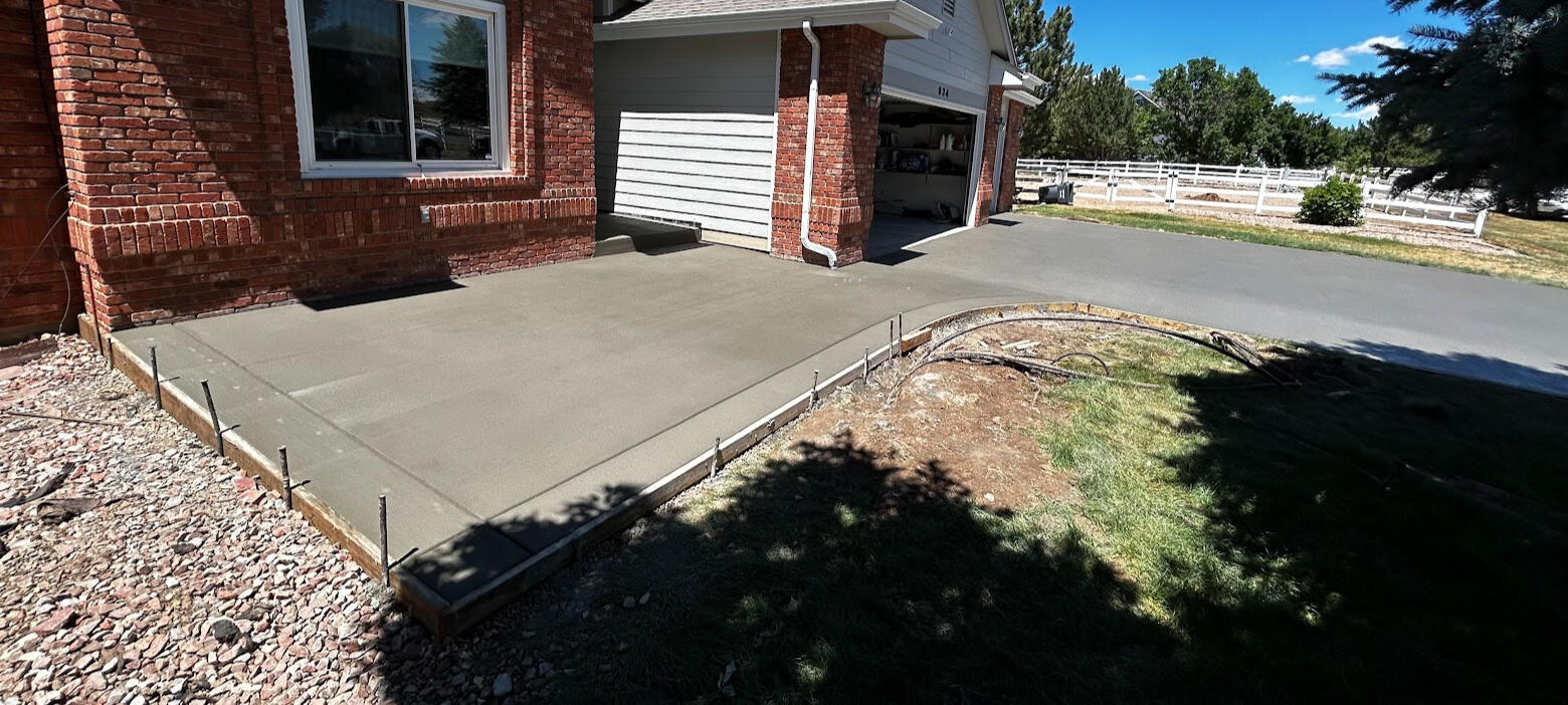 Concrete driveway and porch in Severance, CO with a smooth broom finish, designed for durability and clean curb appeal
