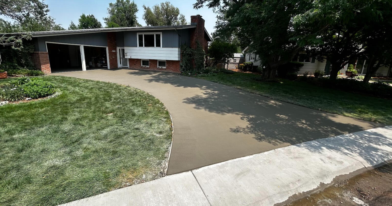 Large curved concrete driveway in Fort Collins, Colorado with a smooth broom finish, providing durable and functional access