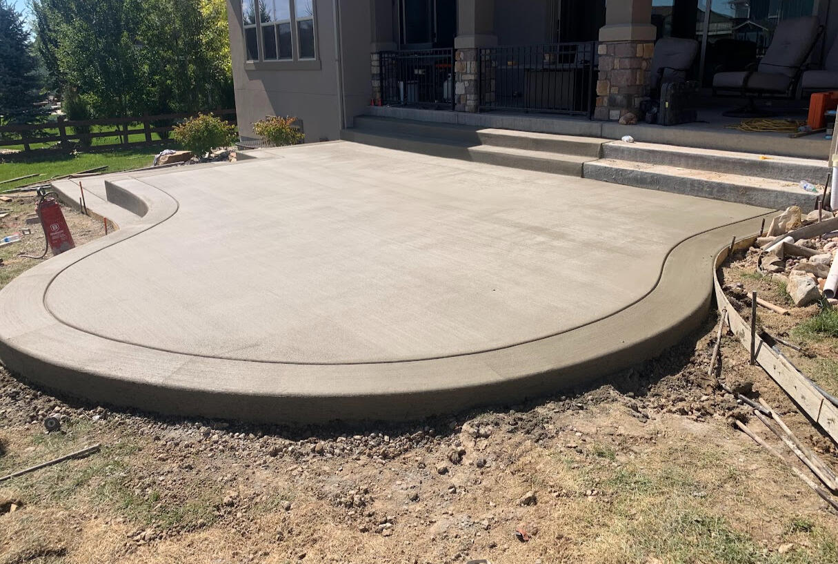 Curved concrete patio with steps in Fort Collins, Colorado featuring a smooth finish and decorative rounded edges