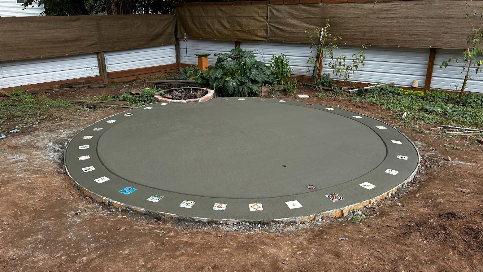 Circular concrete patio in Fort Collins, CO with decorative inlays and smooth finish, designed for a unique outdoor living space