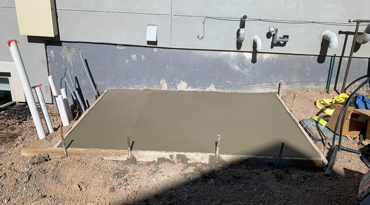 Small concrete utility pad poured near home foundation