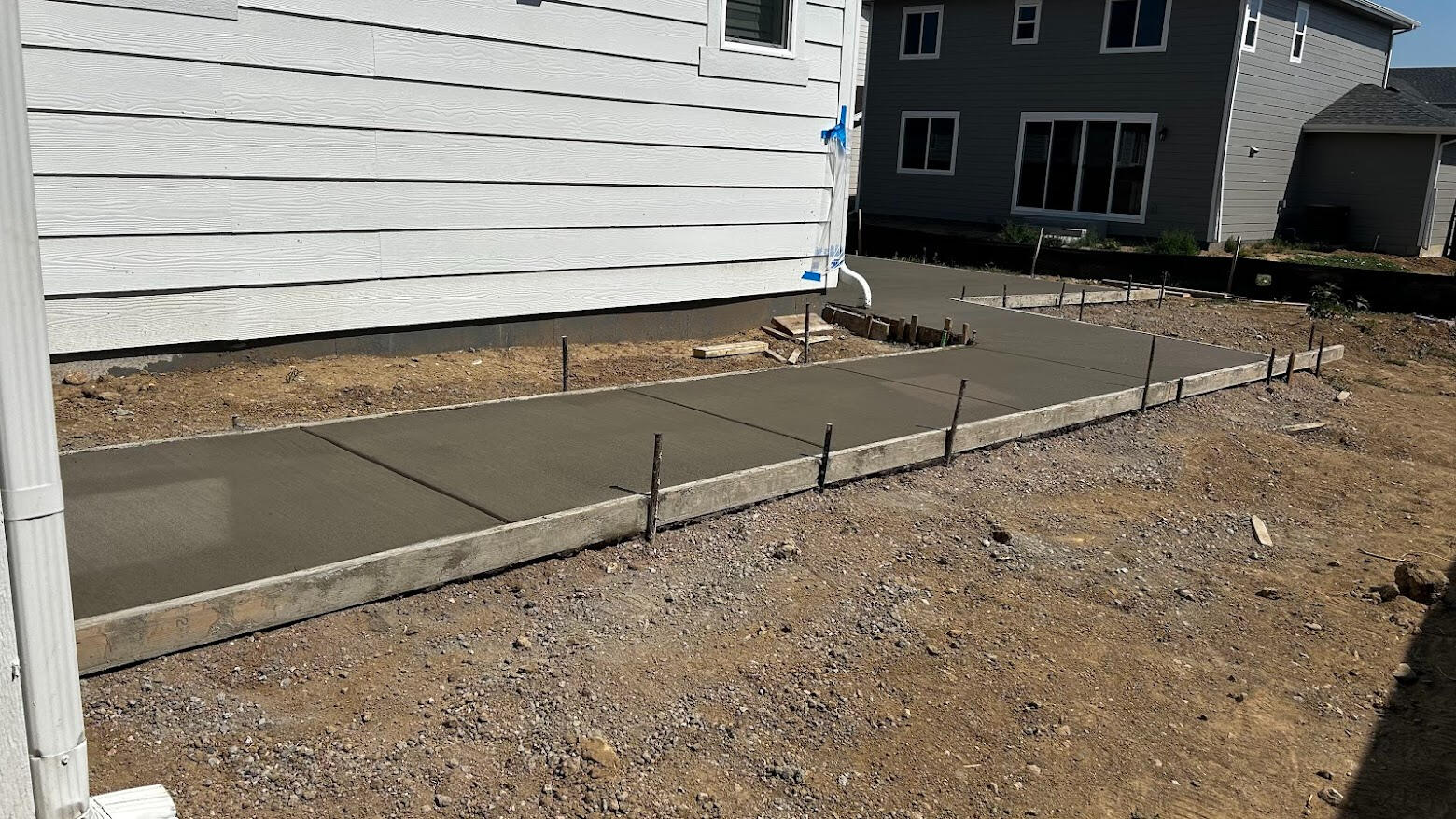 Freshly poured straight concrete sidewalk alongside house with broom finish in Timnath, CO