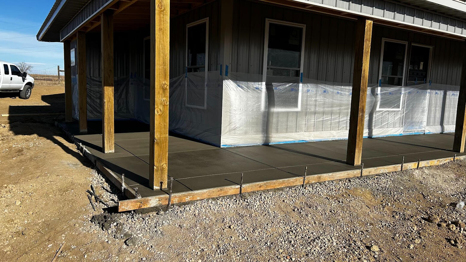 Freshly poured concrete front porch slab on barndominium in Berthoud, CO