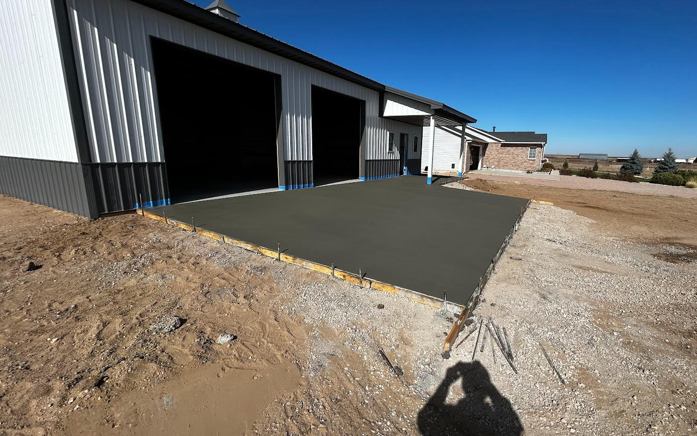 New concrete apron slab in front of large metal shop building, clean edges and smooth finish in Pierce, Colorado