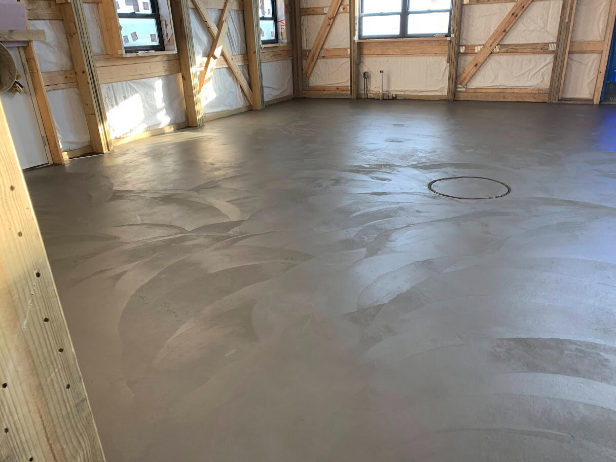 Detailed view of newly poured concrete floor inside a barndominium with smooth troweled finish in Longmont, CO